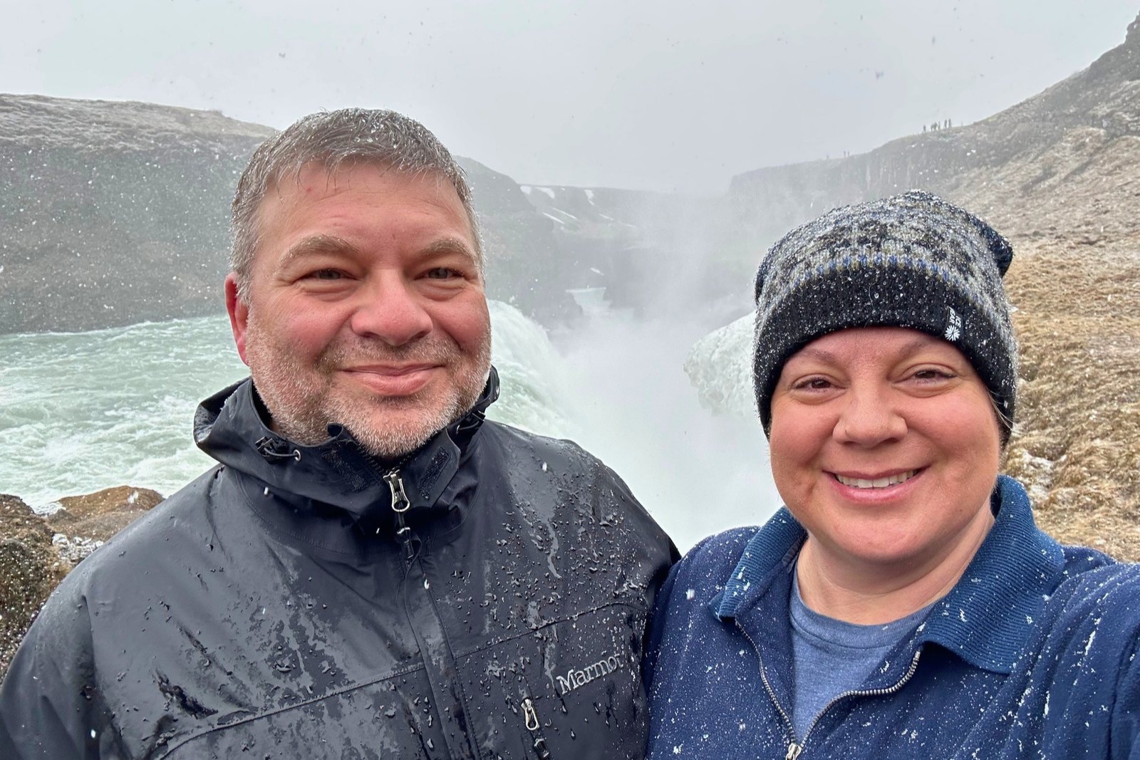 Chris and Erika Commisso in falling snow at the edge of the Gullfoss gorge.