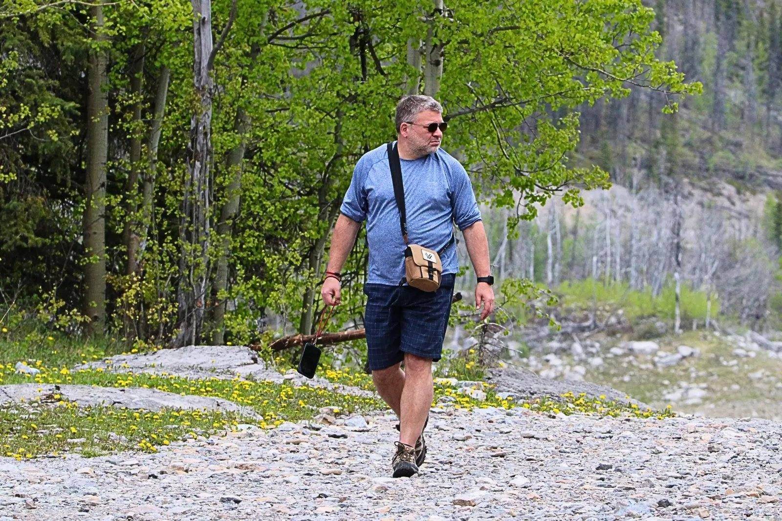 Chris Commisso hiking a rocky trail through aspen forest in Jasper.