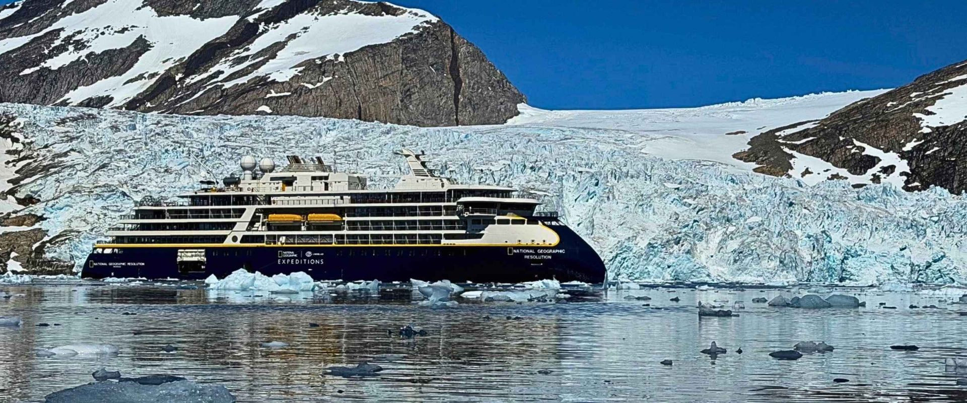 National Geographic Resolution in front of a tidewater glacier in East Greenland, showing her Ulstein X-Bow hull.