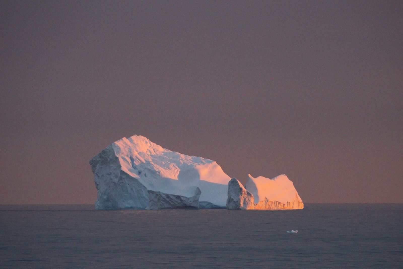 An iceberg glowing orange in the sunset off Gourdin Island.