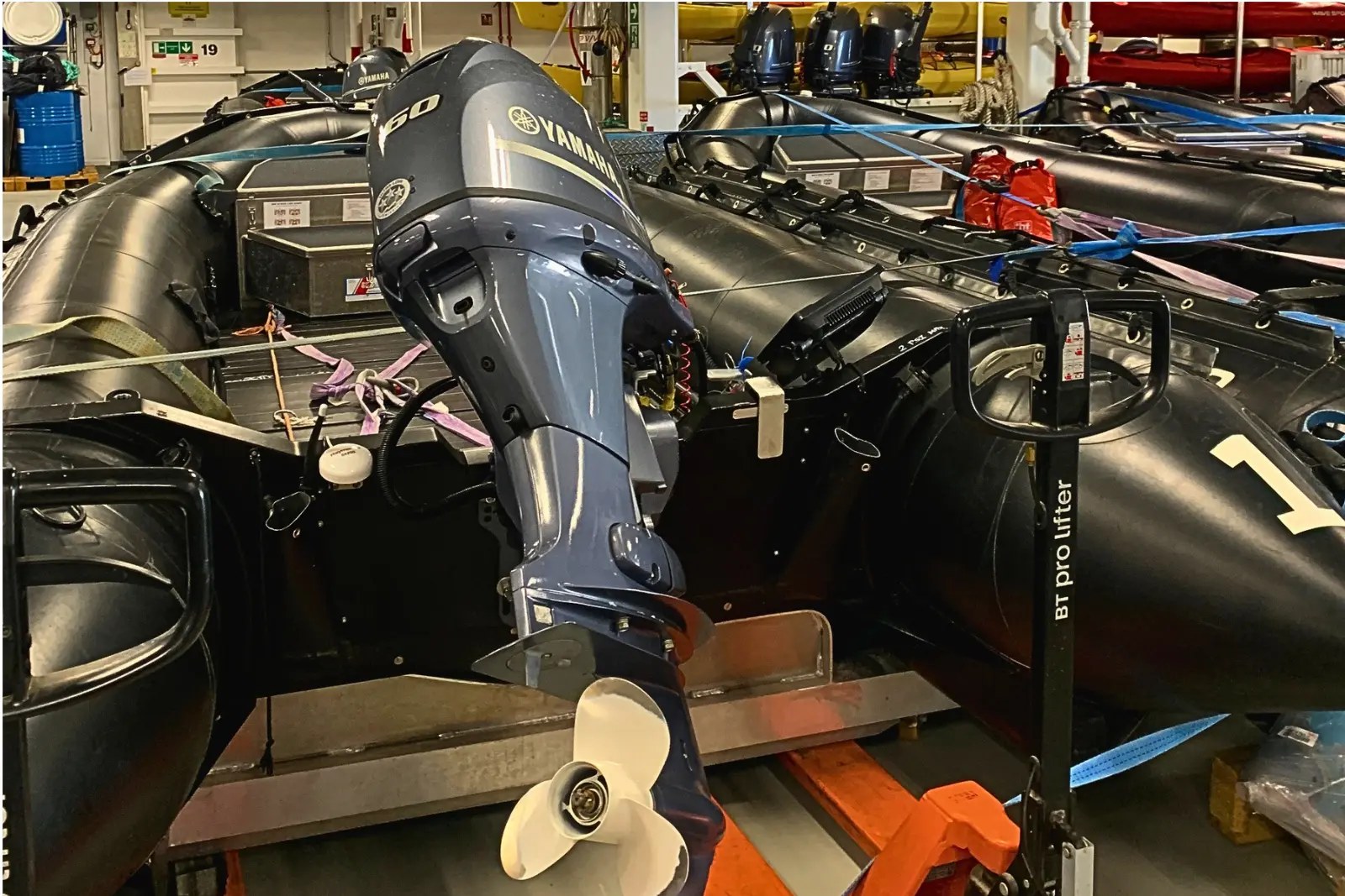 Black Zodiacs with outboard motors stored in the launch area inside the Roald Amundsen.