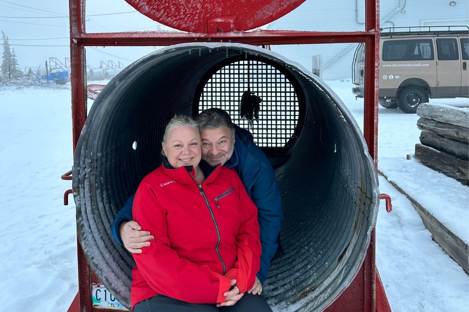 Chris and Erika Commisso sitting inside a culvert-style polar bear trap outside the holding facility.