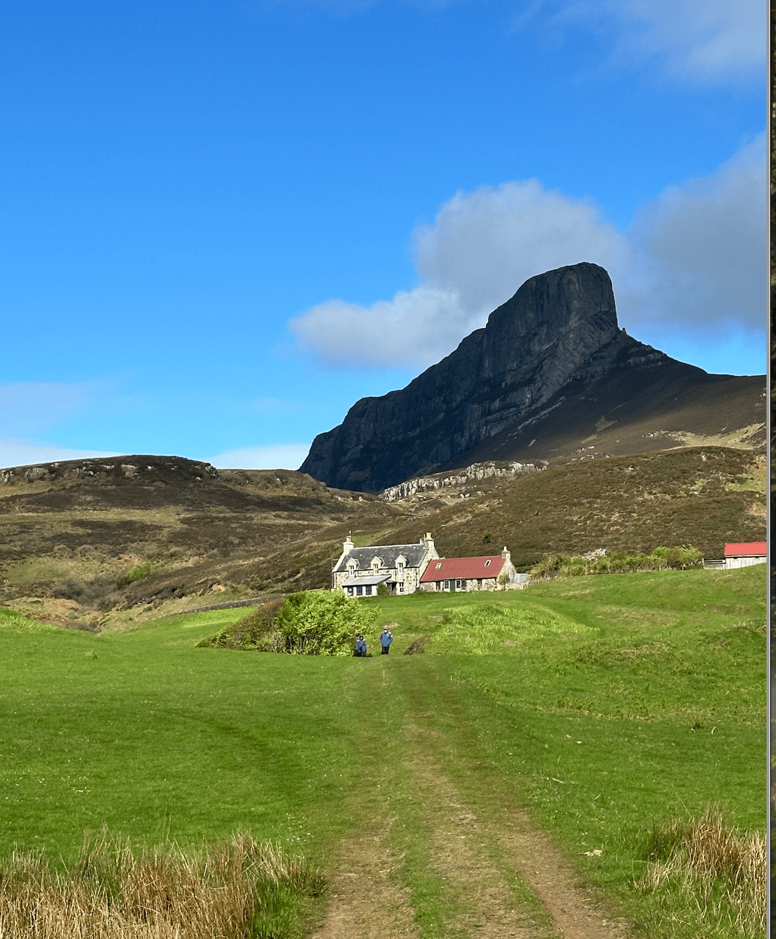 The abandoned village street on Hirta, St Kilda, with stone cleits and cottages below steep green slopes.